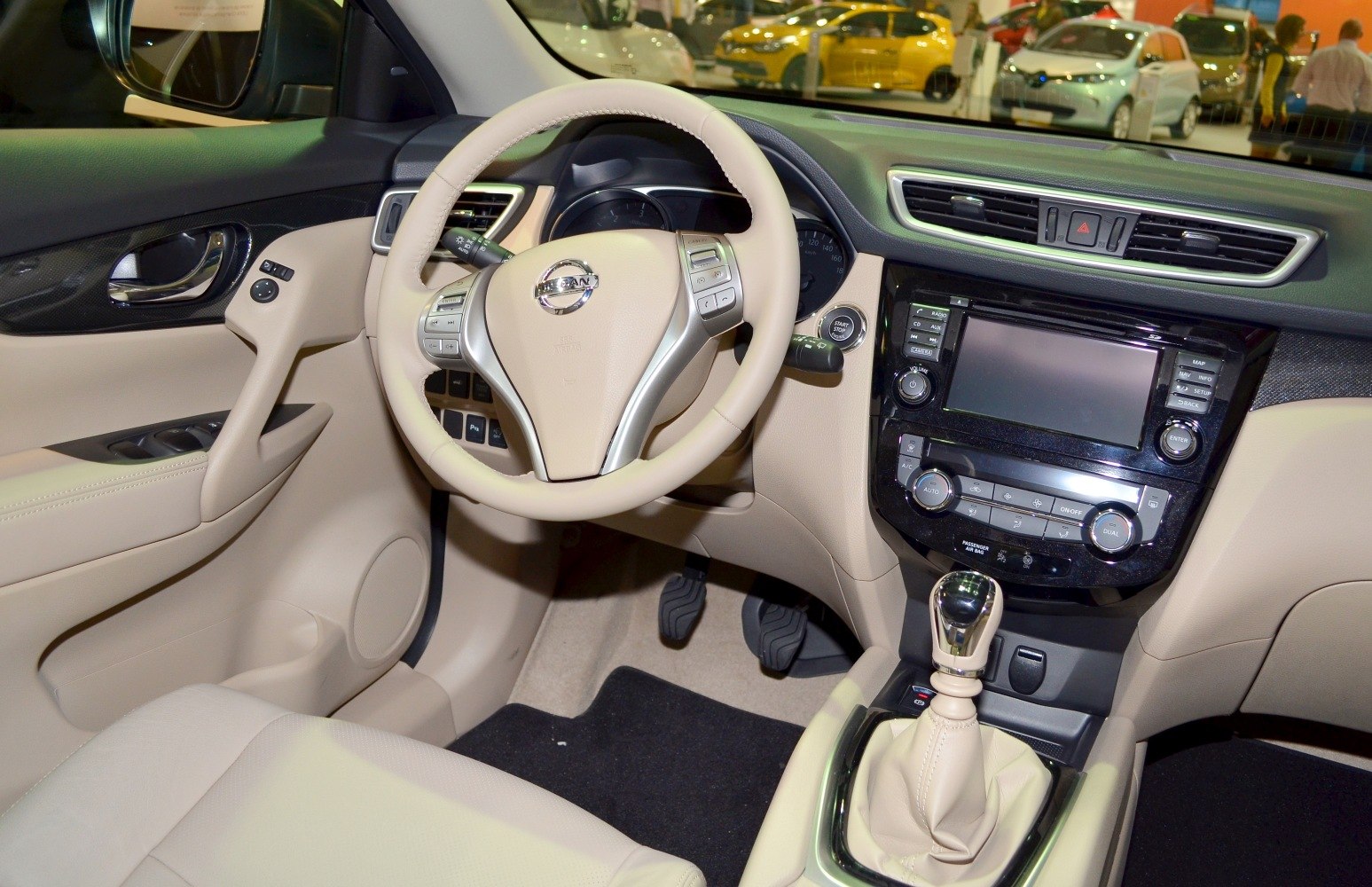 Beige steering wheel, dashboard, and center console with manual gear shift