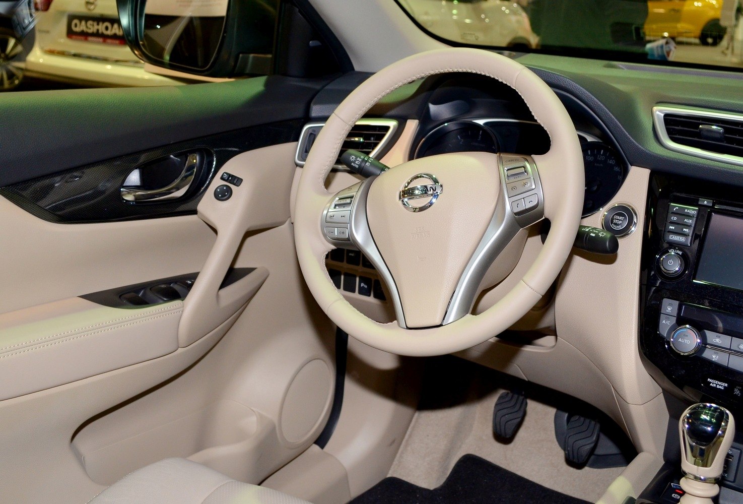 Beige car interior with steering wheel and dashboard controls