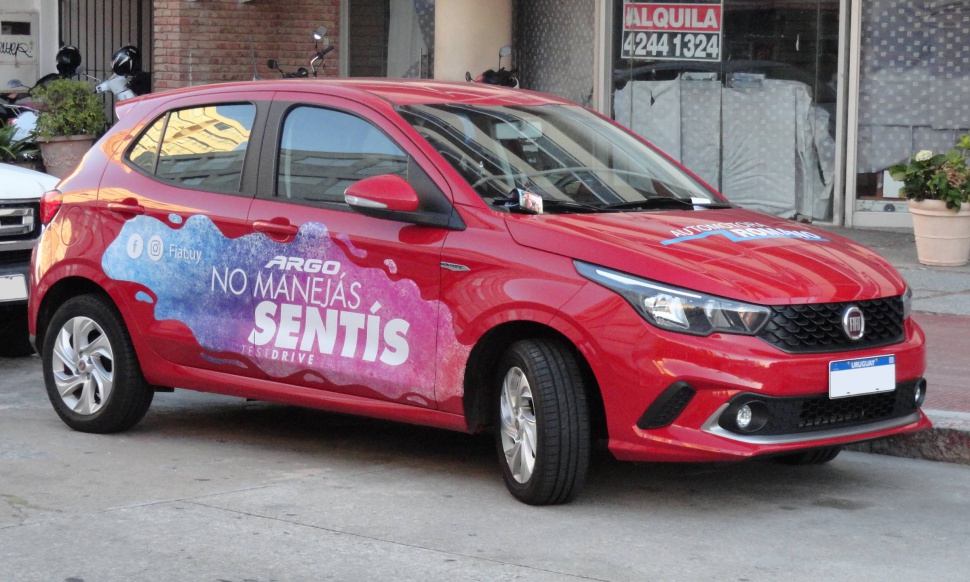 Red hatchback with promotional graphics on side