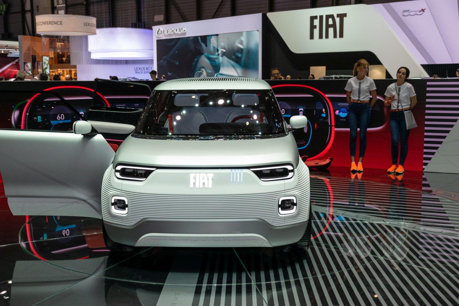 Front view of a compact EV concept with distinctive LED headlights and open door.