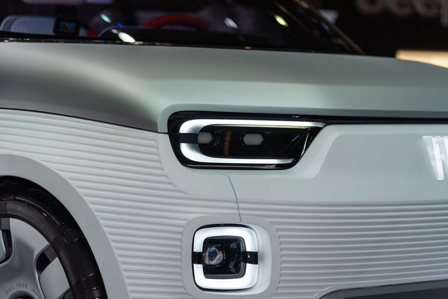 Futuristic front headlight and fog light design with textured front panel.