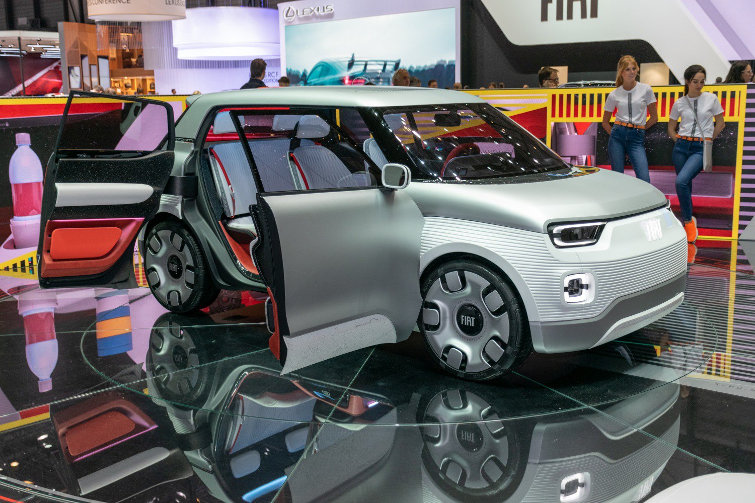 Futuristic compact electric vehicle with open doors and modular interior.