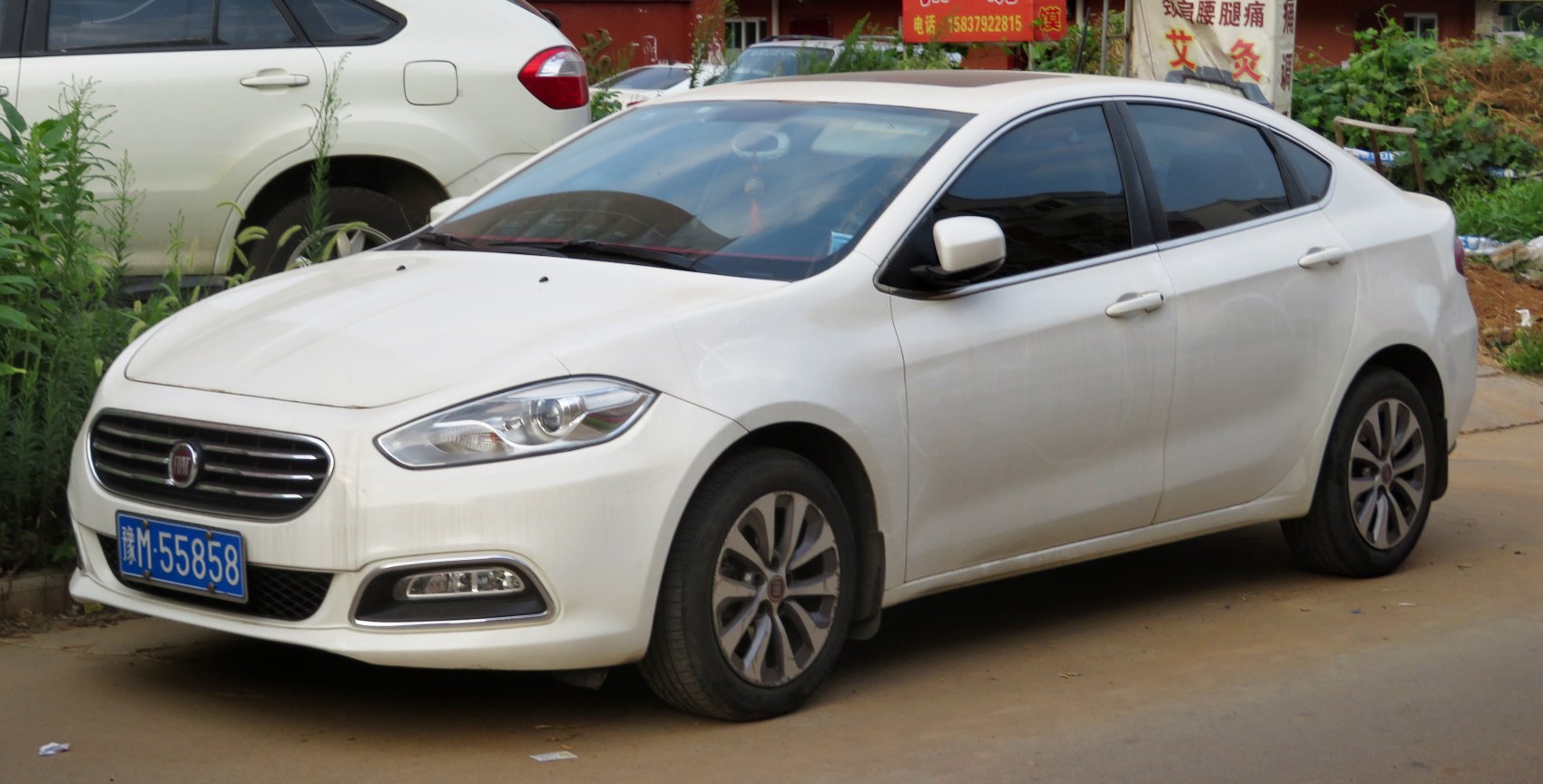 Front side view of sedan with alloy wheels and headlights