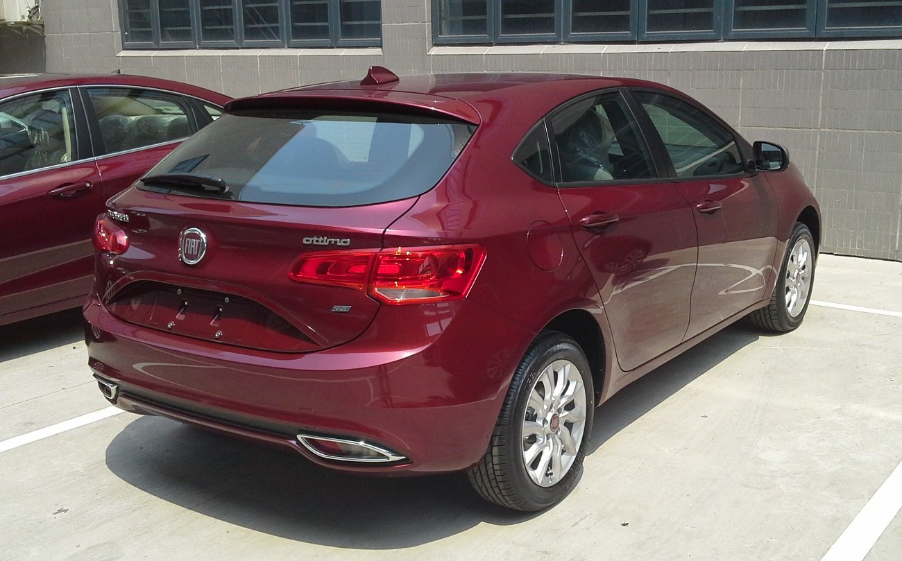 Red hatchback rear and side view with distinctive rear lights and alloy wheels.