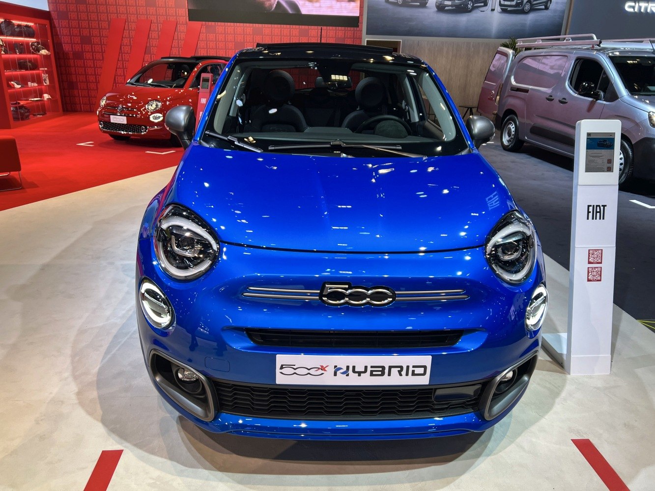 Front view of blue hybrid vehicle with round LED headlights and grille