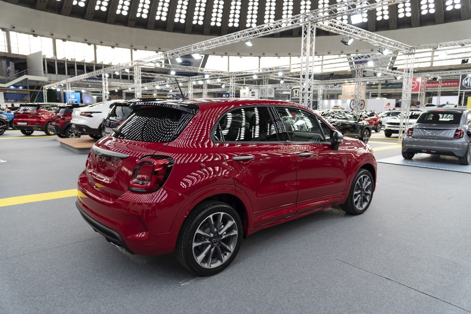 Sporty red SUV rear and side view with modern wheels in exhibition