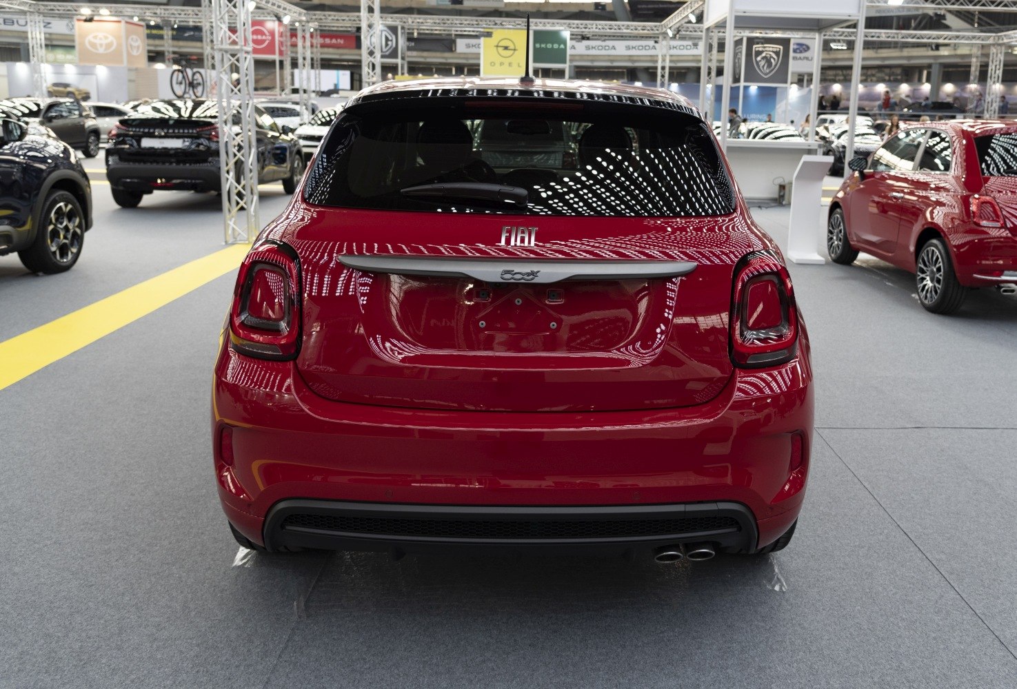 Rear view of red compact hatchback with modern taillights and dual exhaust pipes
