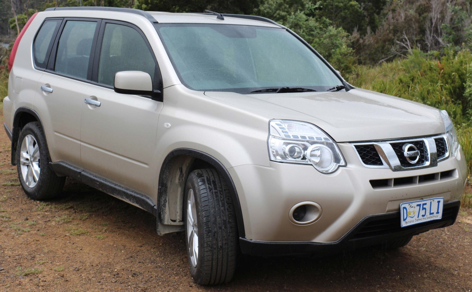 Silver SUV front angle with headlamps and grille on dirt