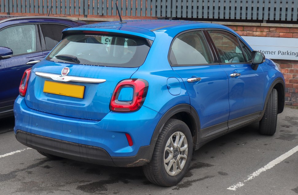 Rear three-quarters view of blue compact SUV with distinctive taillights and roof spoiler