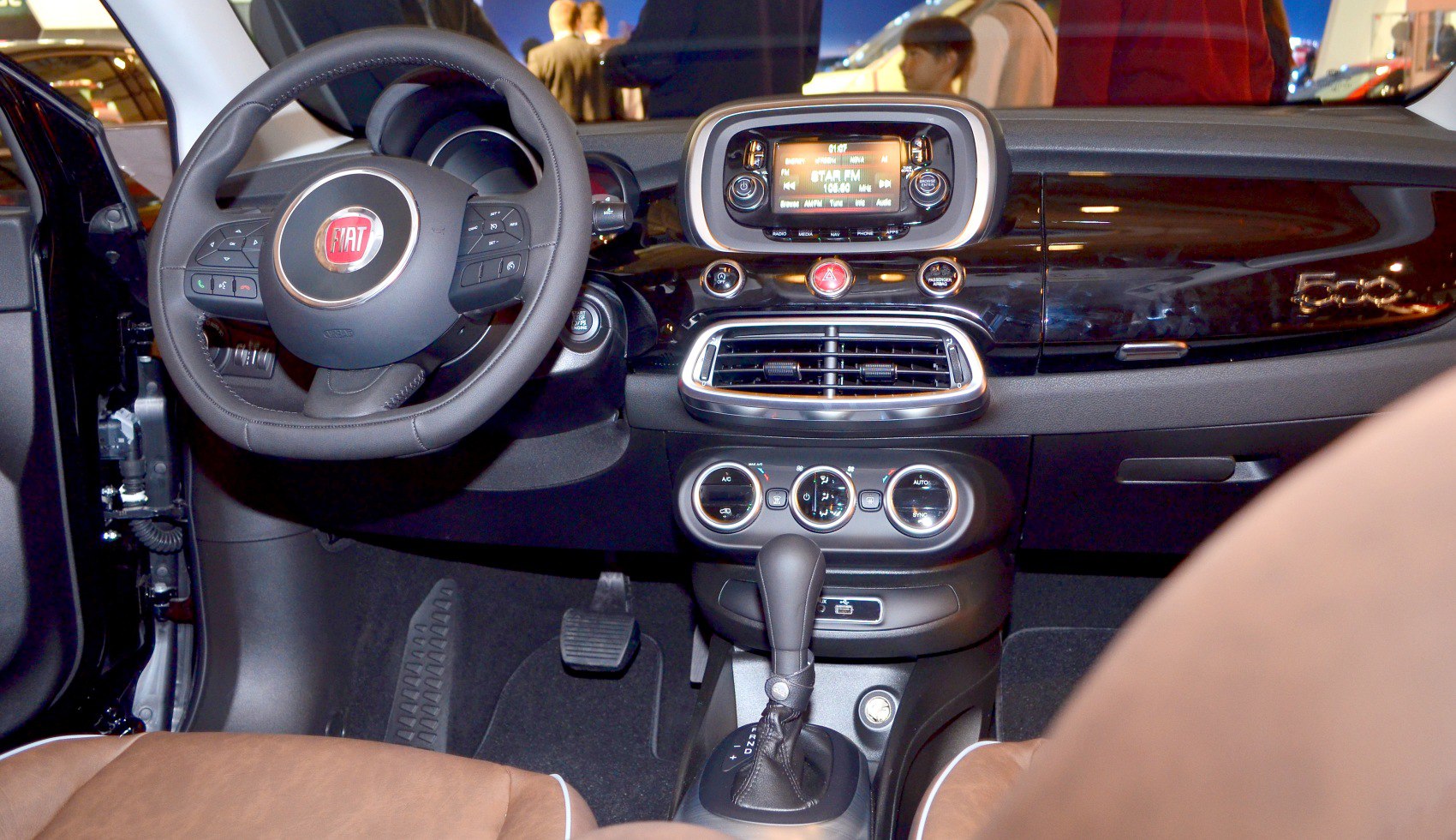 Steering wheel with controls, central infotainment system, and dashboard layout