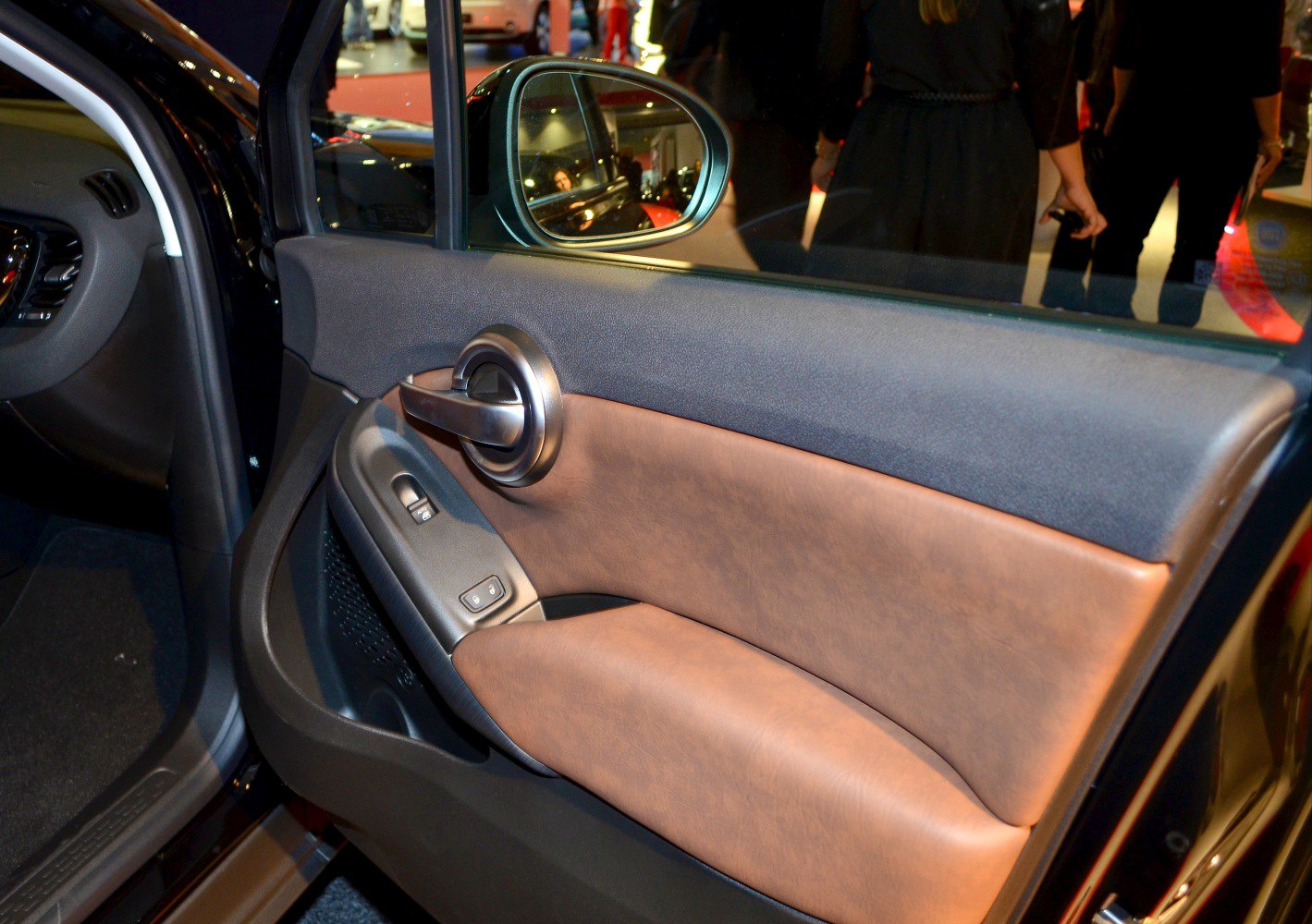 Leather interior door panel with chrome handle and window controls.