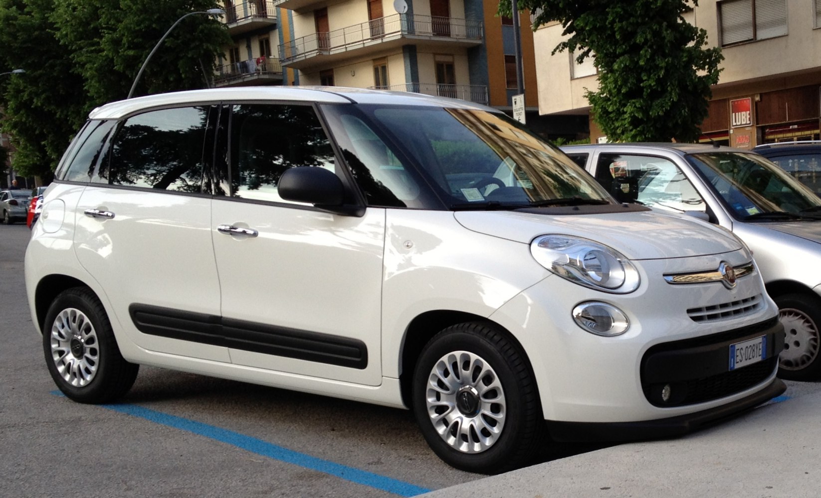 Compact vehicle side view with distinctive round headlights and white body