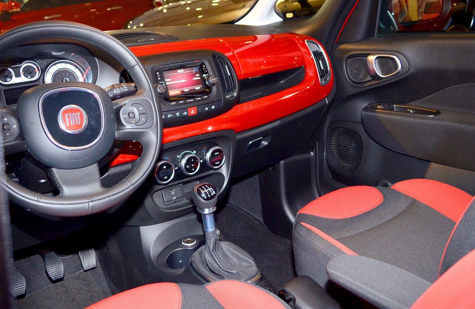 Red dashboard, multifunction steering wheel, manual gear shift, black and red seats