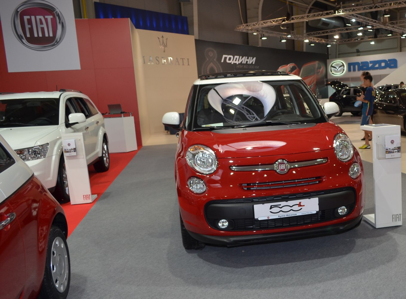 Front view of red compact vehicle with round headlights and grille.