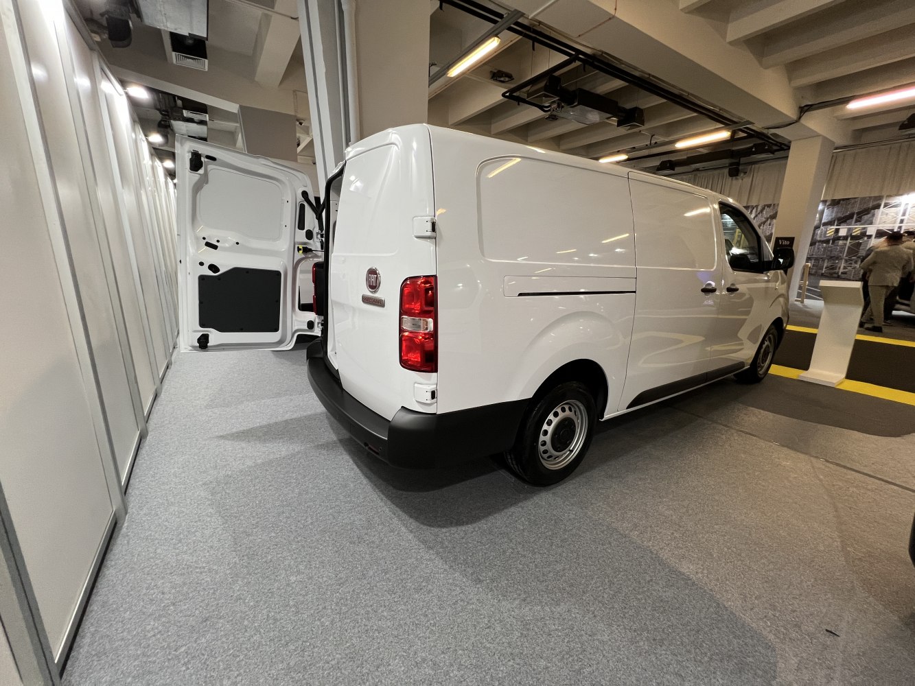 Rear side view of panel van with open rear door.