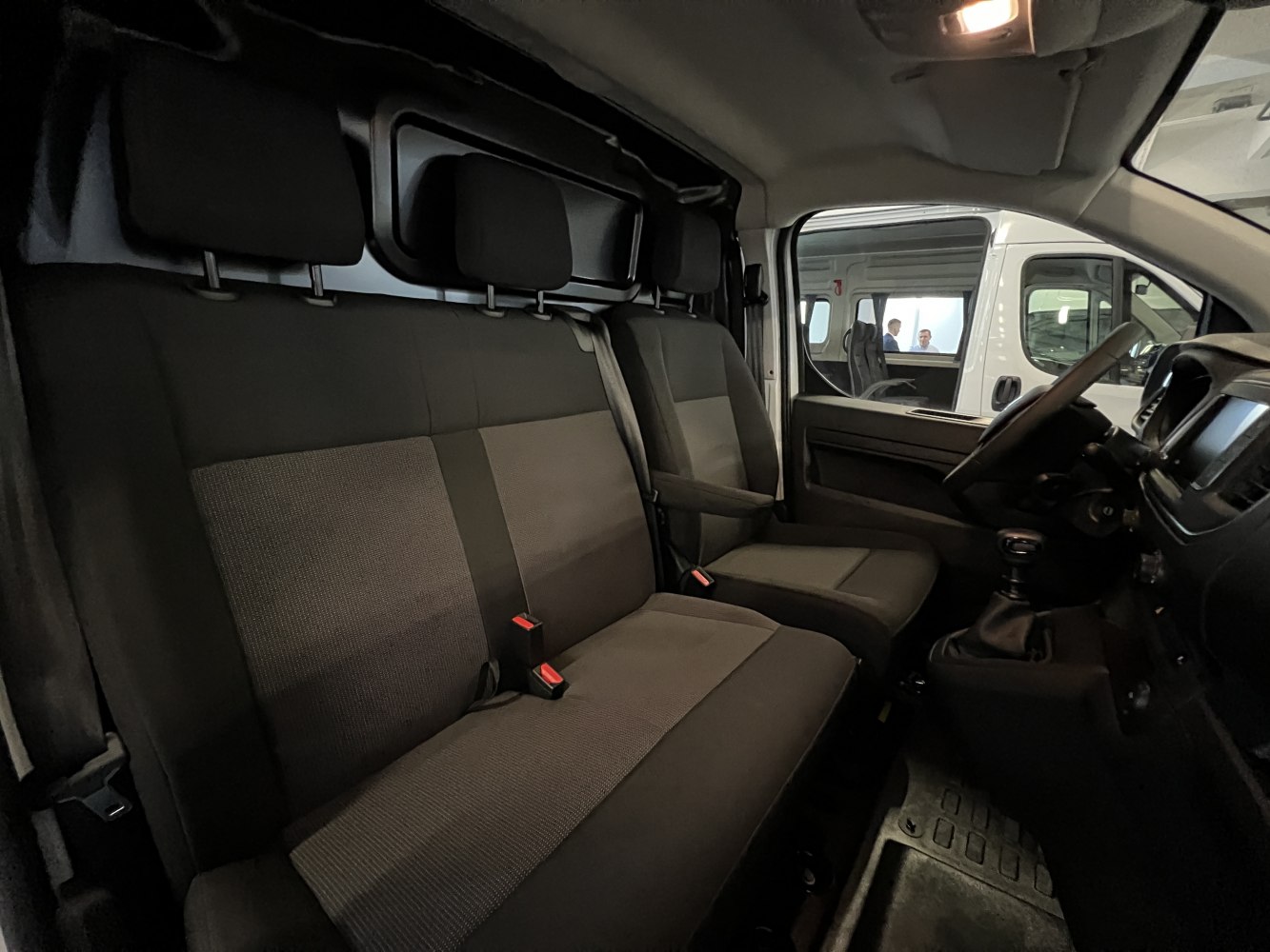 Three-seat front cabin with ergonomic seats and driver dashboard.