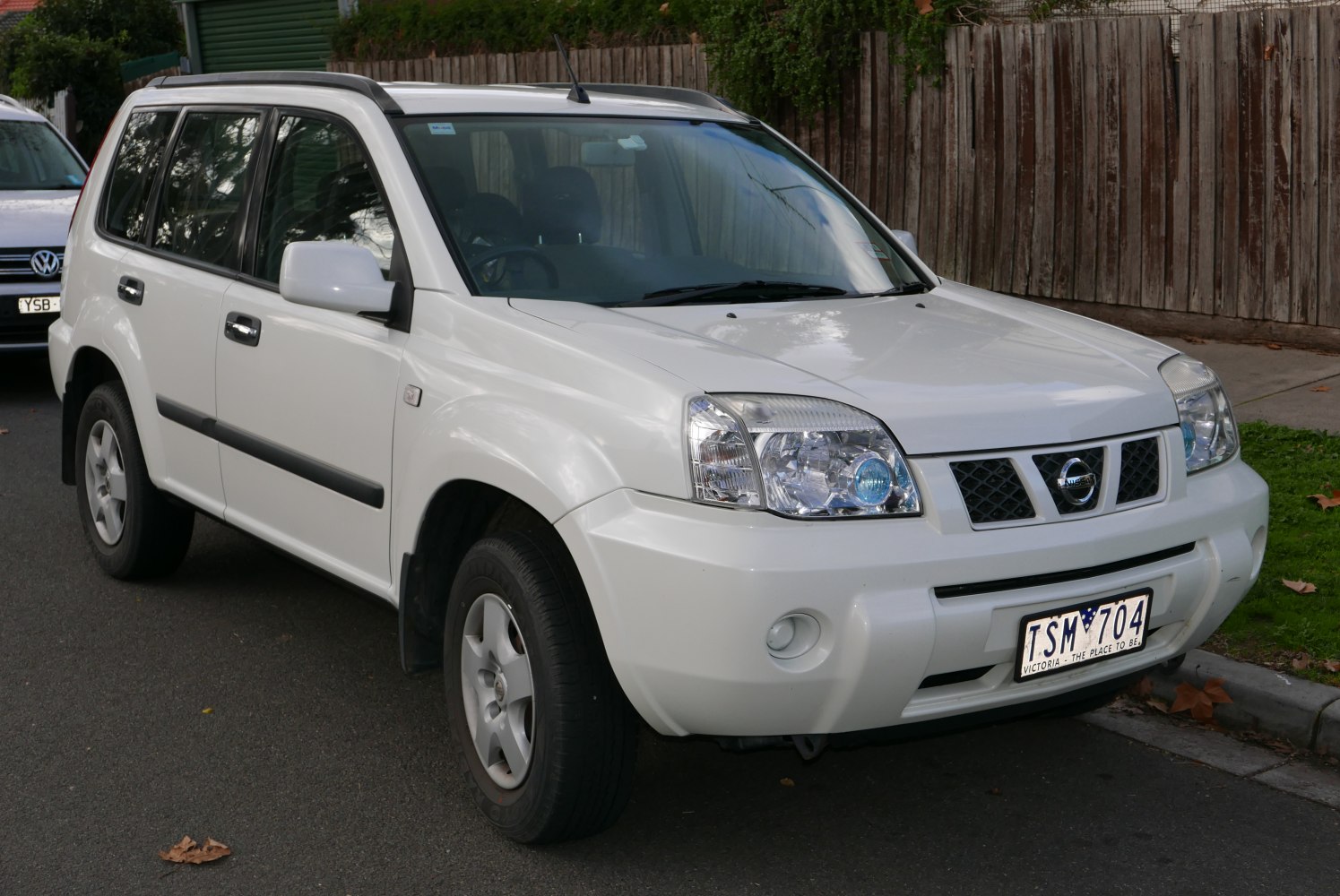 Front and side view of a white SUV with distinct headlights and roof rails