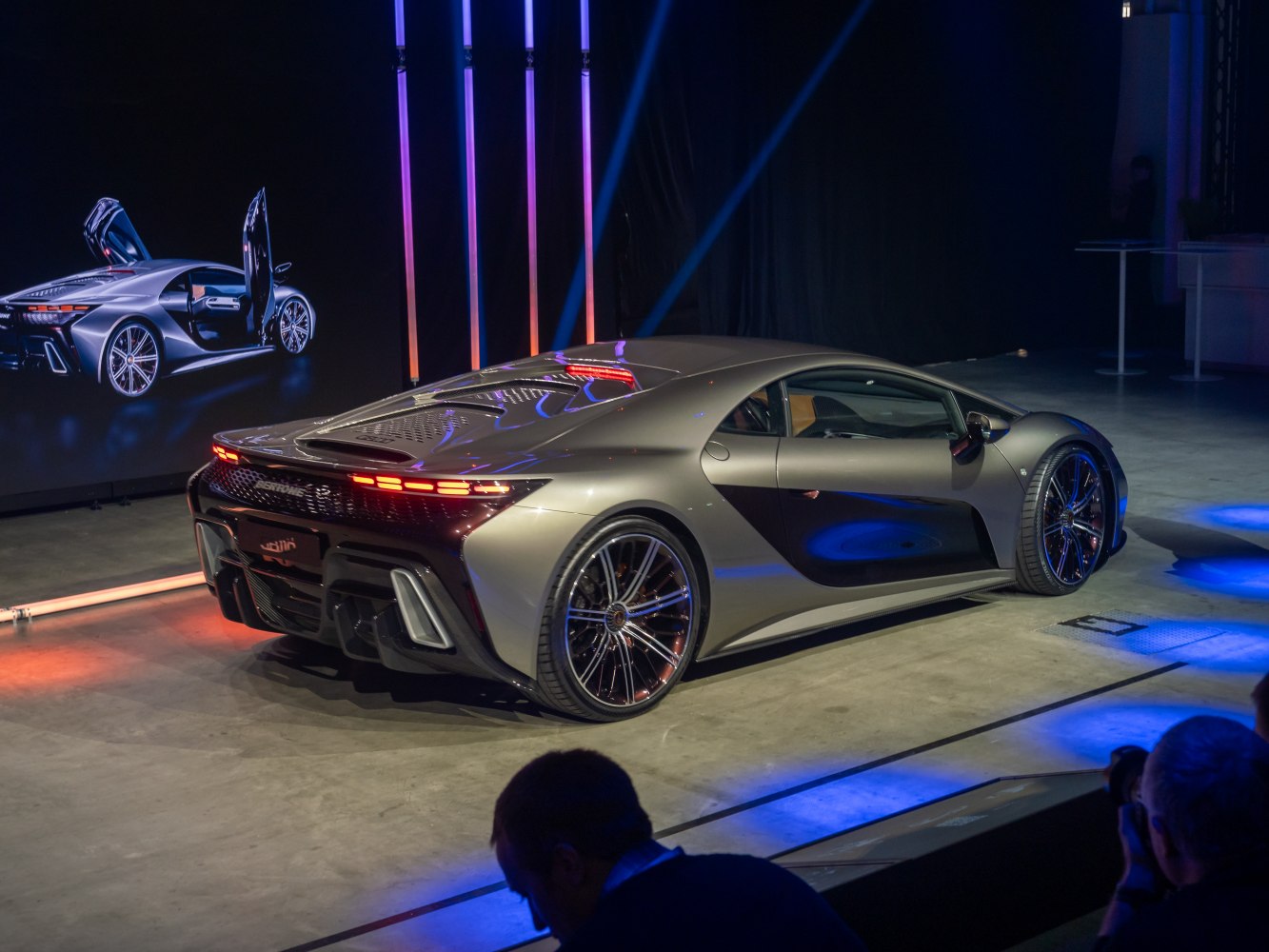 Sleek rear side view with illuminated rear lights and aerodynamic curves