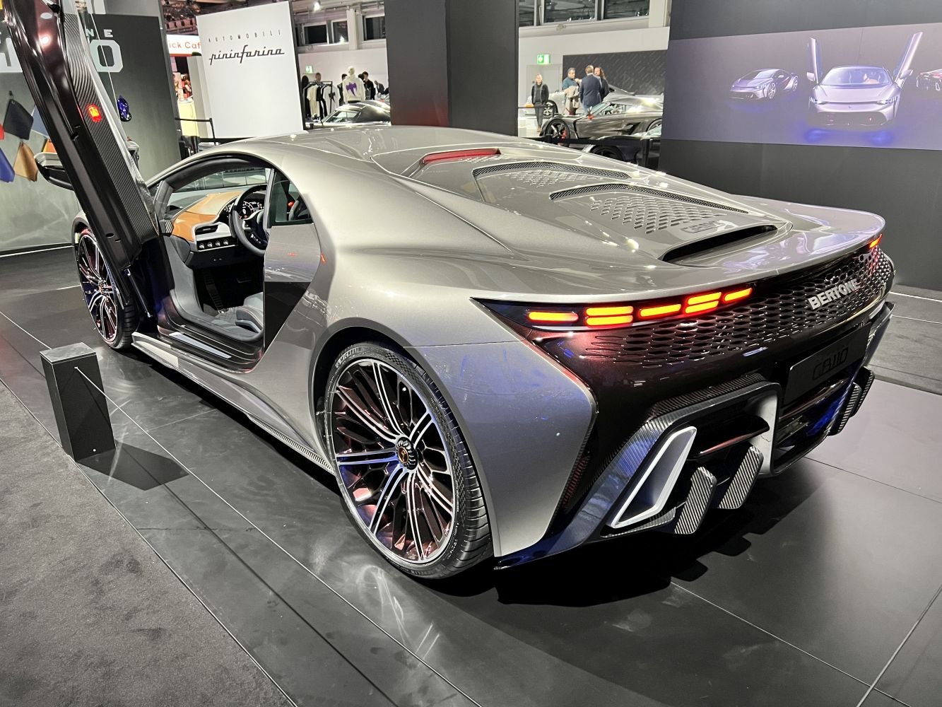 Rear view with illuminated tail lights and open butterfly door