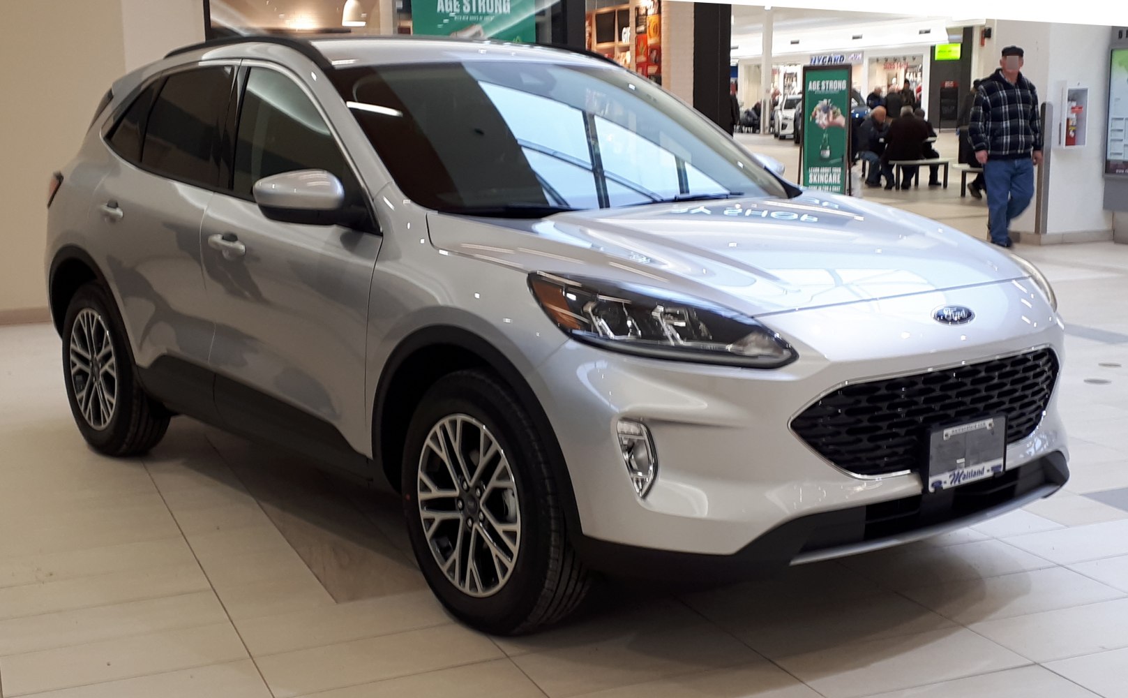 Front-side view of silver SUV with distinct headlights and grille
