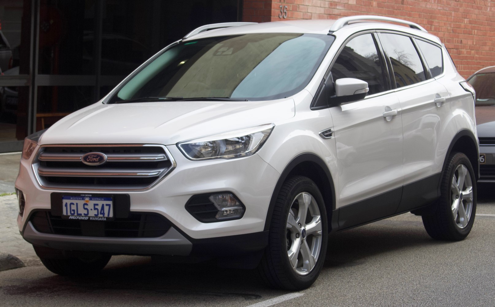 White SUV with chrome grille and roof rails, front side perspective