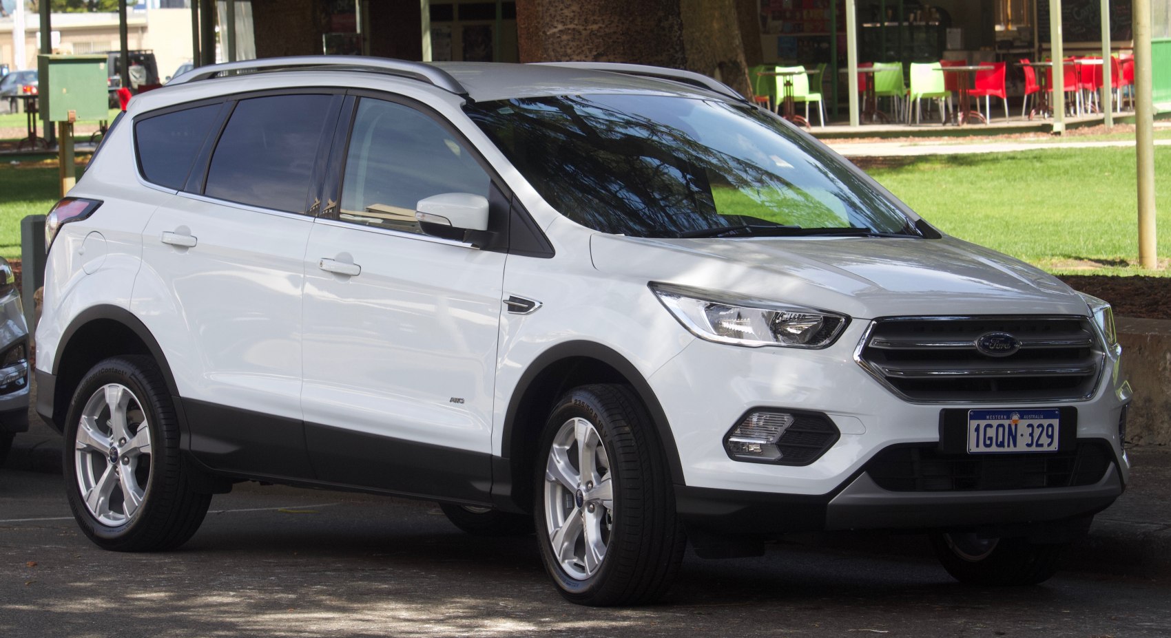 Front side view of white SUV with modern headlights and alloy wheels