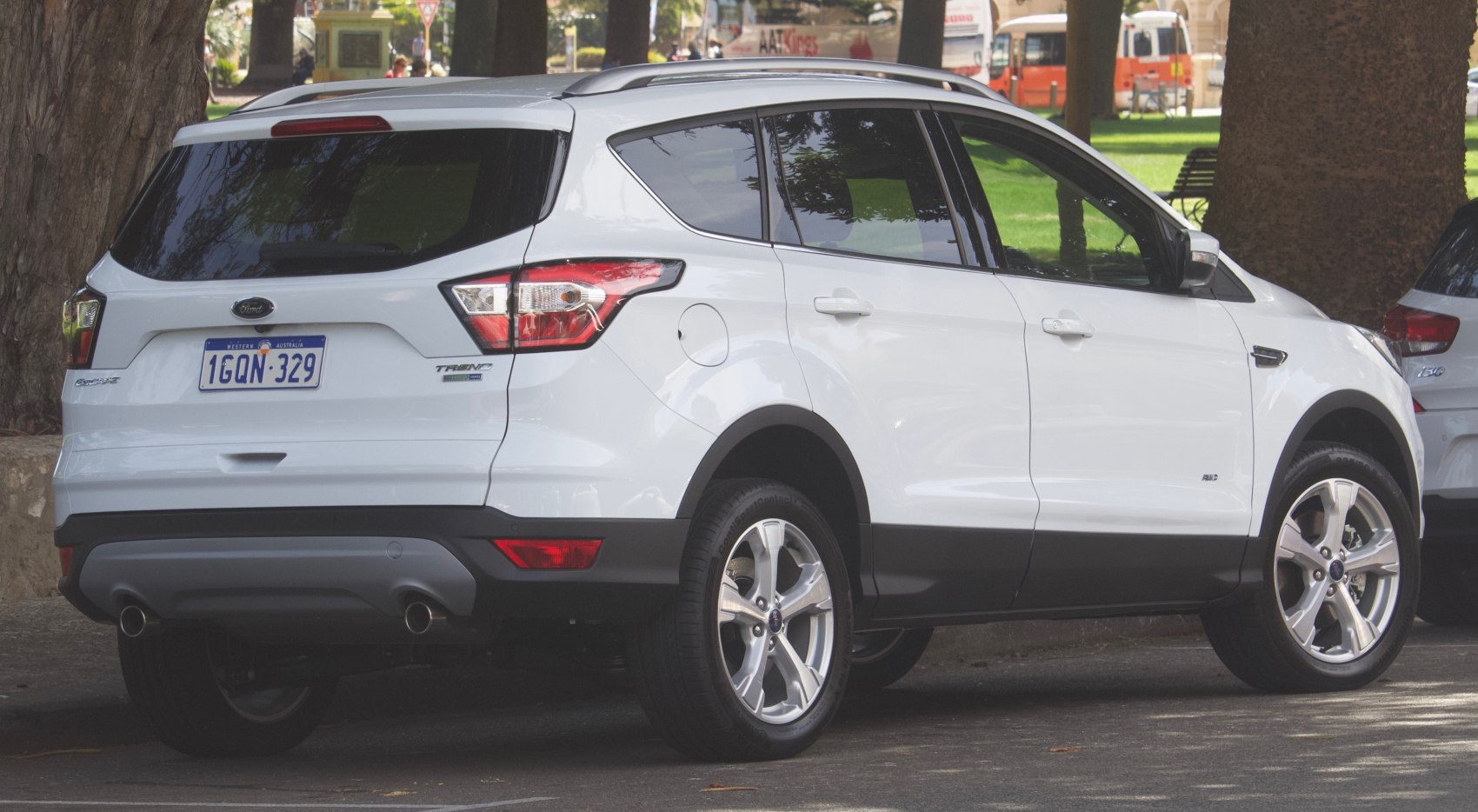 Rear and side view of white SUV with dual exhaust and alloy wheels