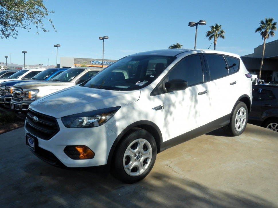 Front and side view of white mid-size SUV with highlighted headlights and wheels