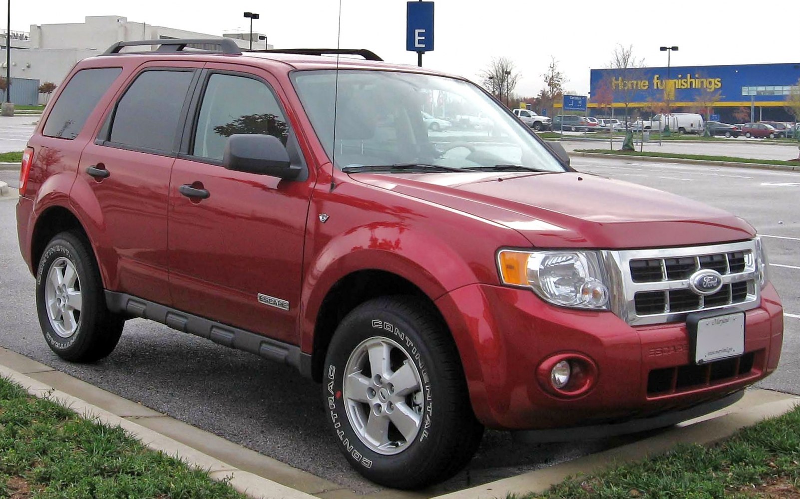 Red SUV with front grille, alloy wheels, and tinted windows