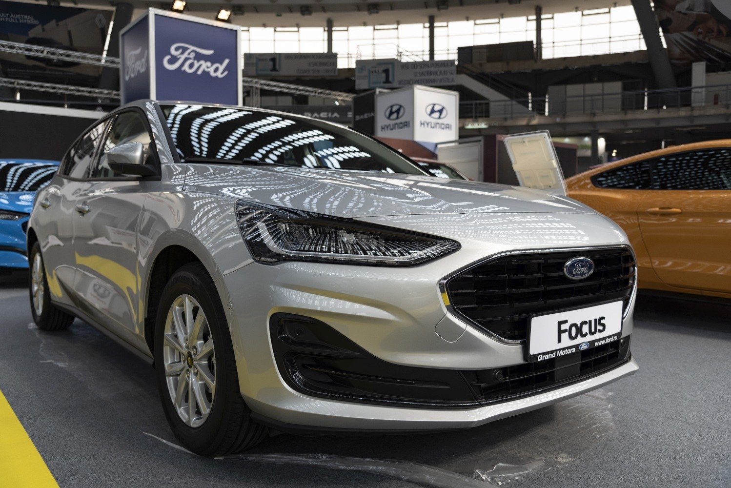 Silver hatchback front with sleek headlights and black grille