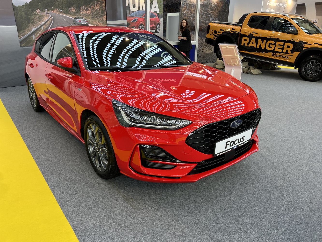 Sporty red hatchback front with LED headlights and honeycomb grille
