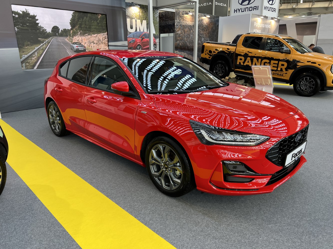 Sporty red hatchback with sleek front design and alloy wheels