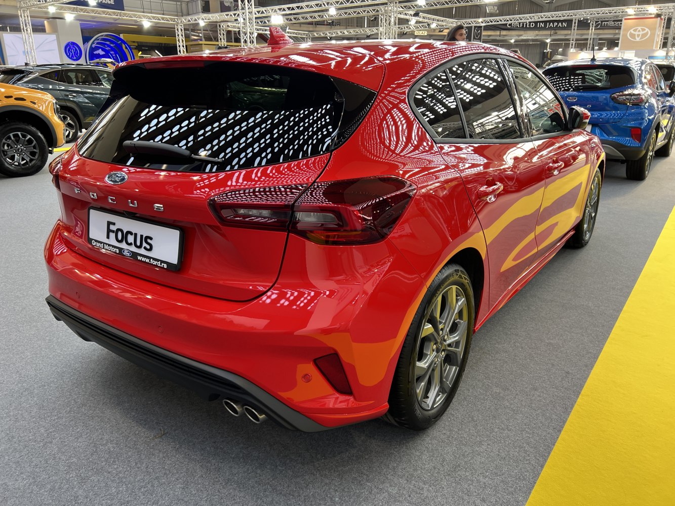 Rear view of a red hatchback with modern taillights and dual exhaust pipes