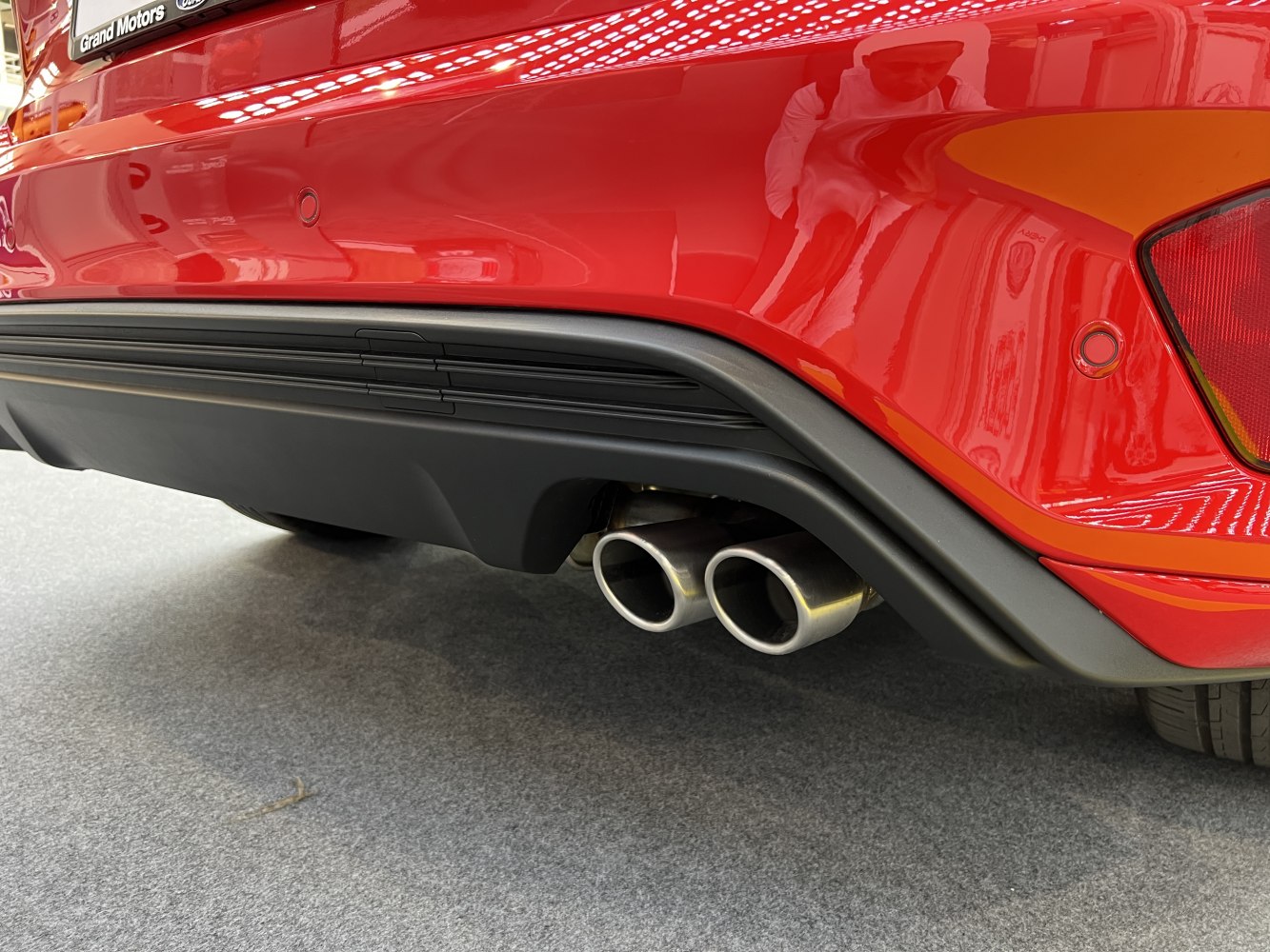 Dual exhaust tips integrated in rear bumper diffuser with red paint