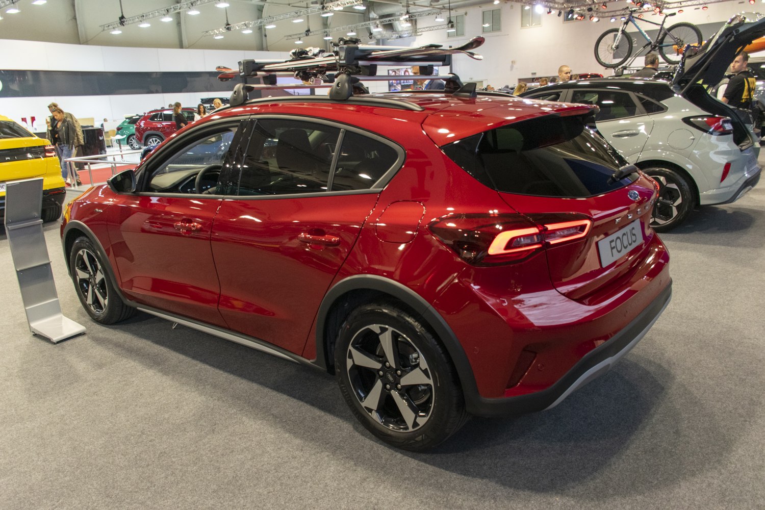 Red hatchback with roof ski rack and modern LED taillights