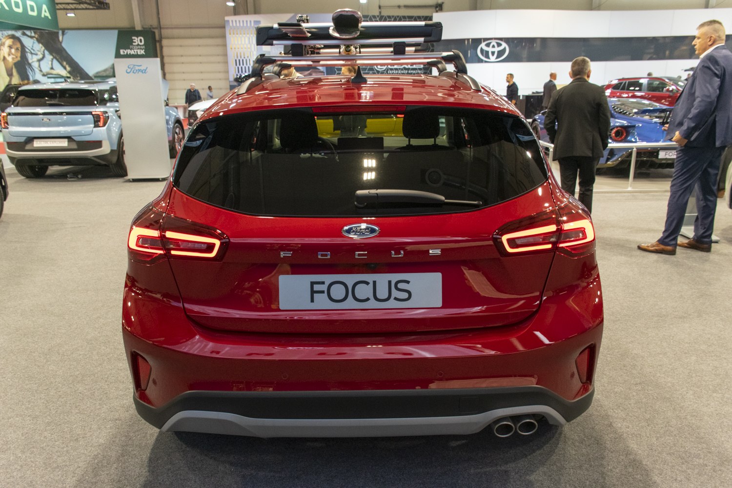 Rear view with illuminated taillights and roof rack of a hatchback.