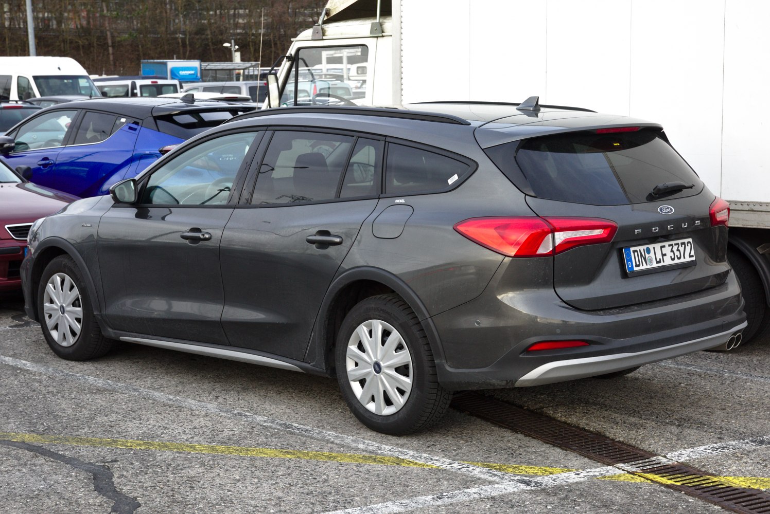 Rear side view of a modern estate car with tinted windows and roof rails