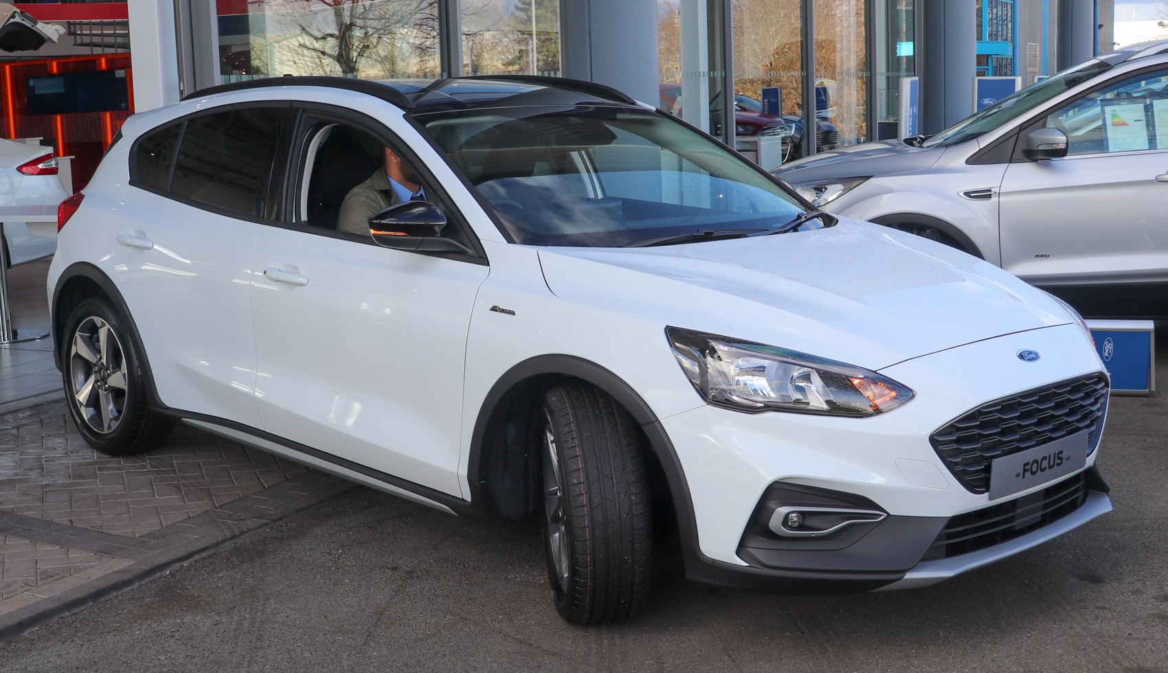 Front and side view of white hatchback with sporty grille and alloy wheels