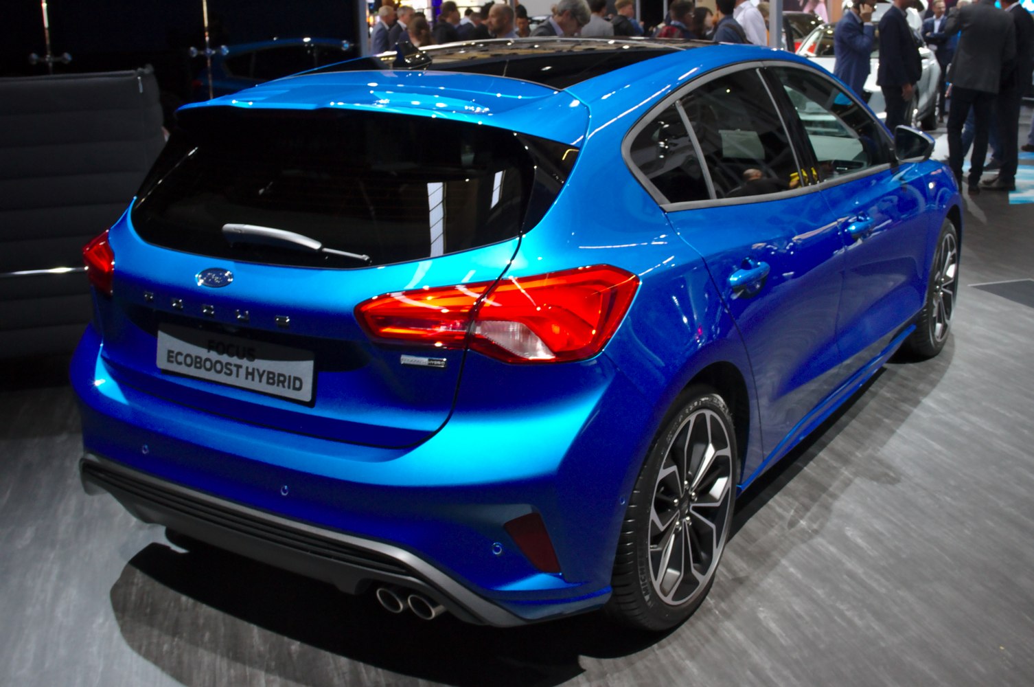 Rear view of a blue hatchback with LED taillights and dual exhaust pipes