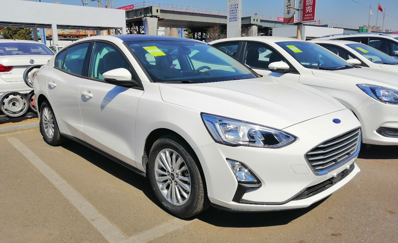 White sedan with sleek headlights and horizontal grille design