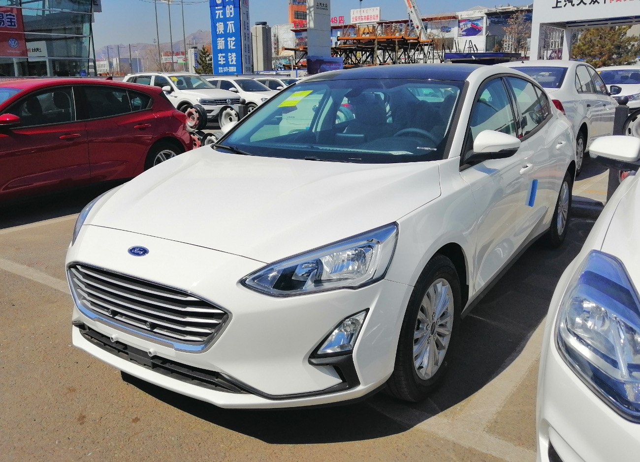 White compact sedan with chrome grille and angular headlights