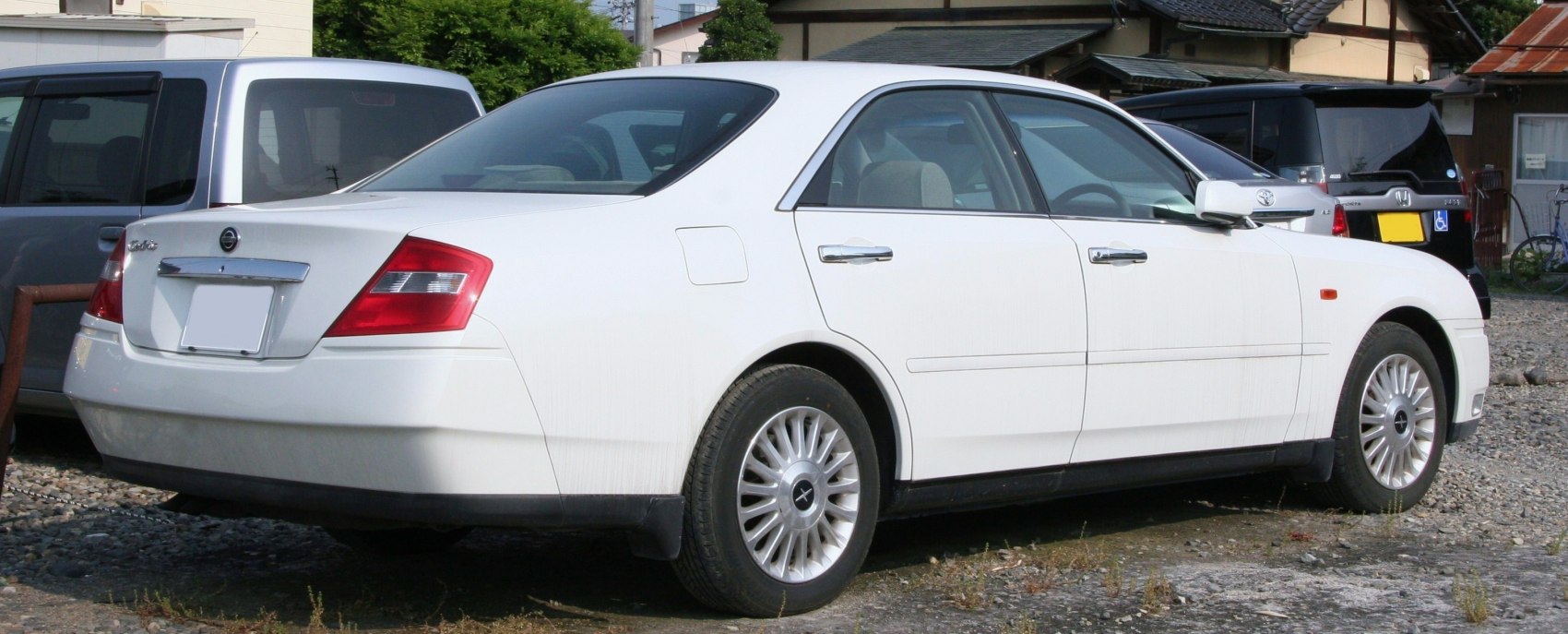 Rear 3-quarter view of white sedan with distinct taillights and wheels