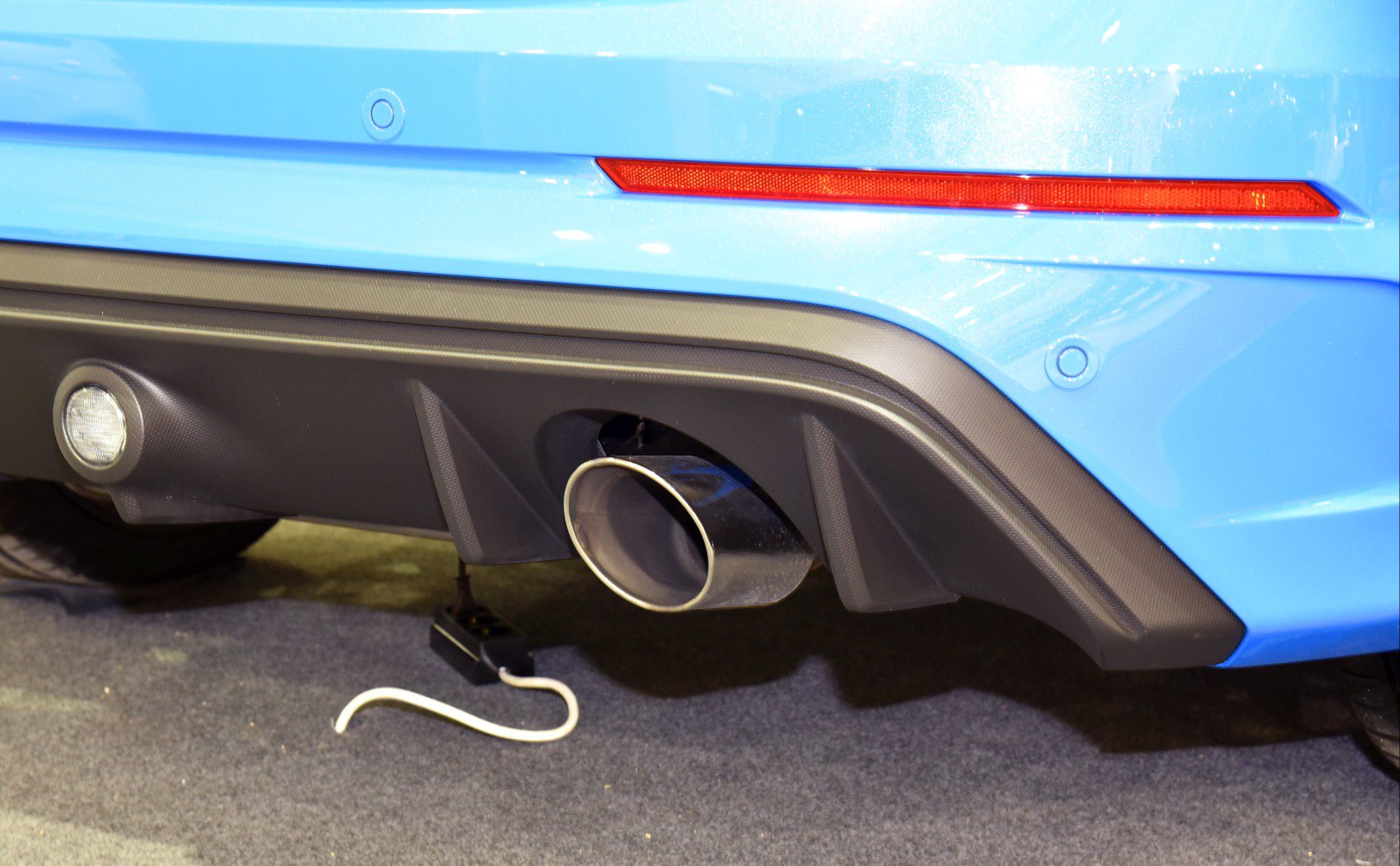Rear diffuser and exhaust pipe with rear reflector and parking sensor