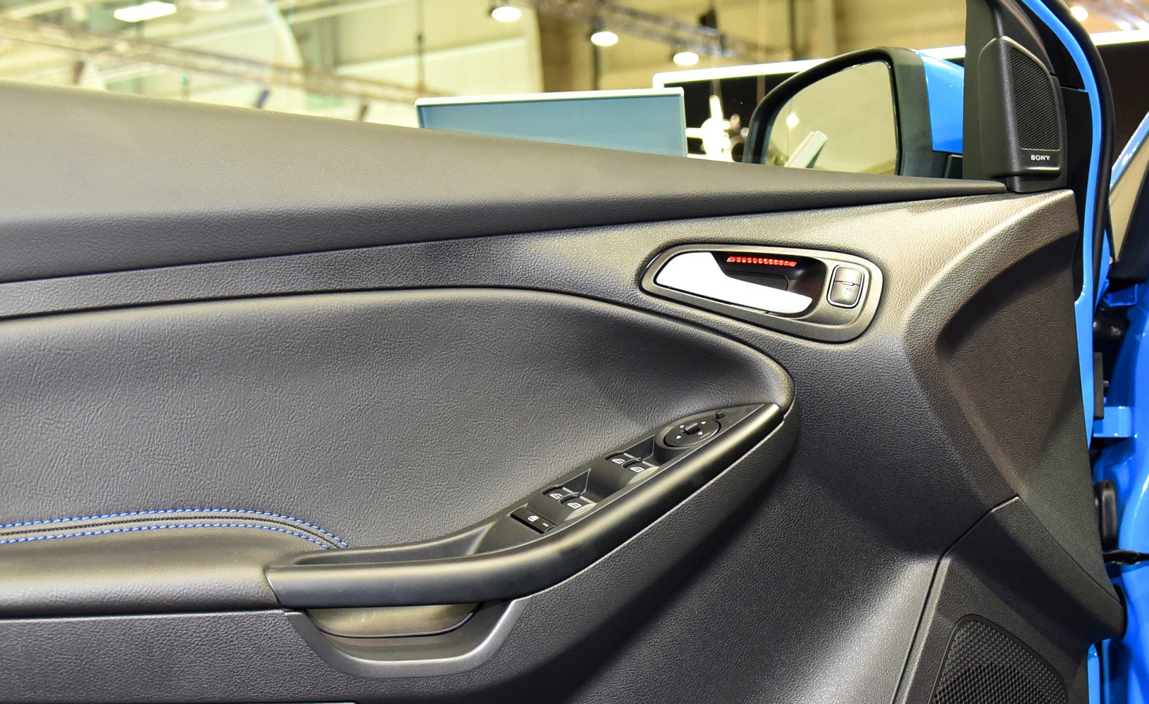 Interior door panel with electronic window controls and side mirror speaker