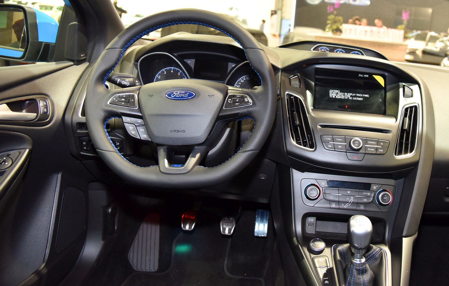 Dashboard, steering wheel with controls, touchscreen, manual gear shifter