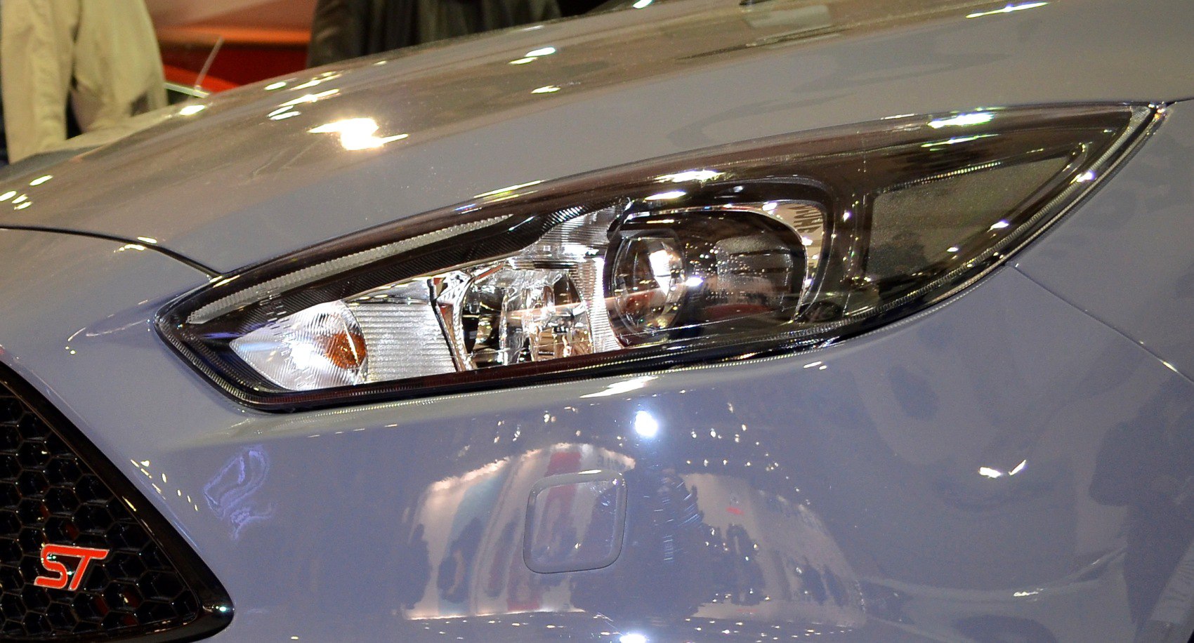 Close-up of front headlight and red ST badge on a hatchback car