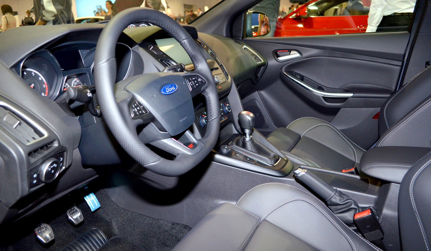 Interior cabin with steering wheel, dashboard, and gear shift.