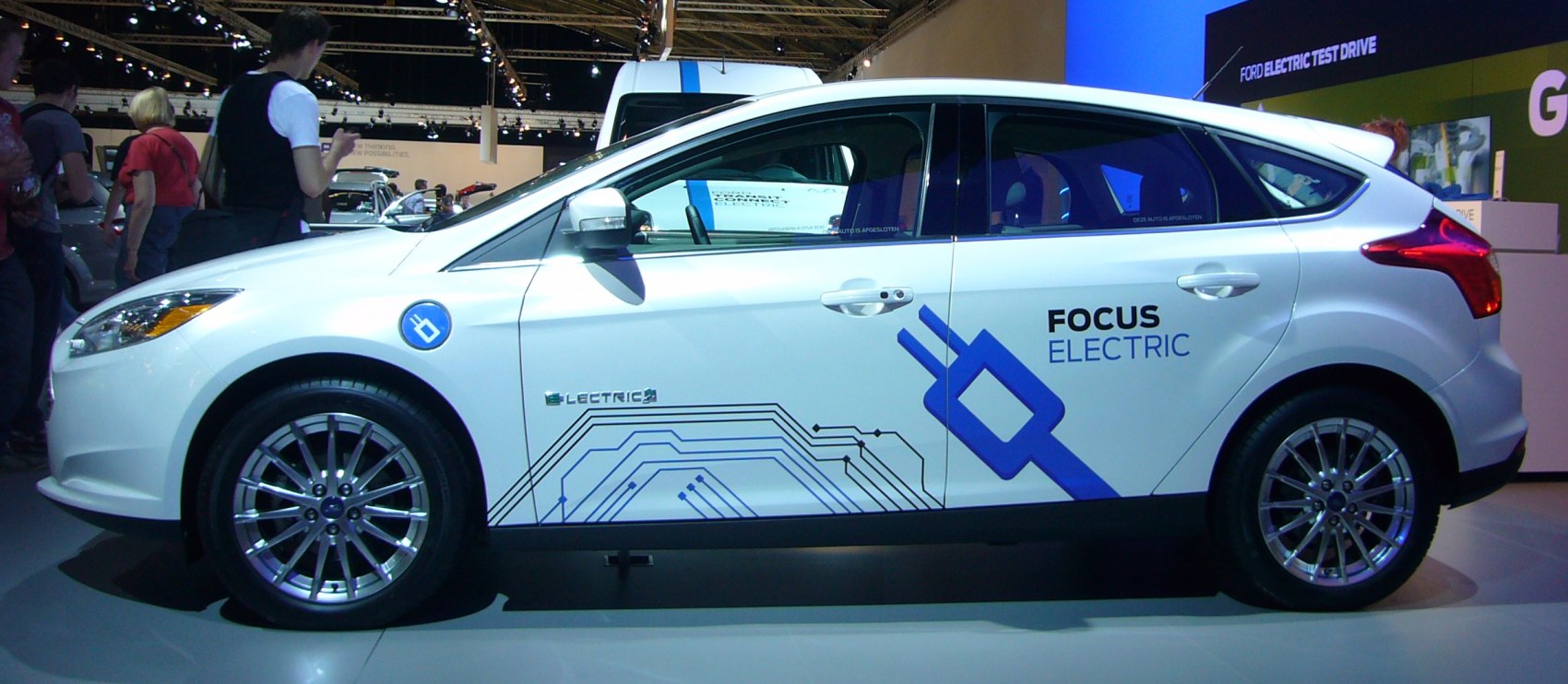 Side view of an electric hatchback with blue electrical decals and alloy wheels