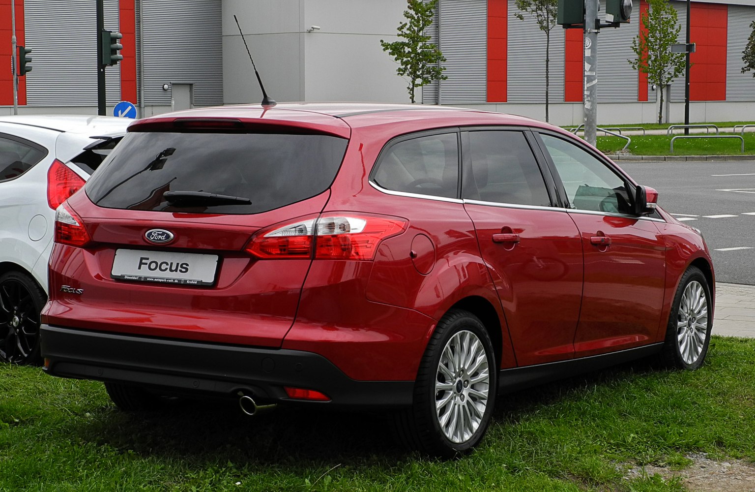 Rear view of a red station wagon with tinted windows and alloy wheels