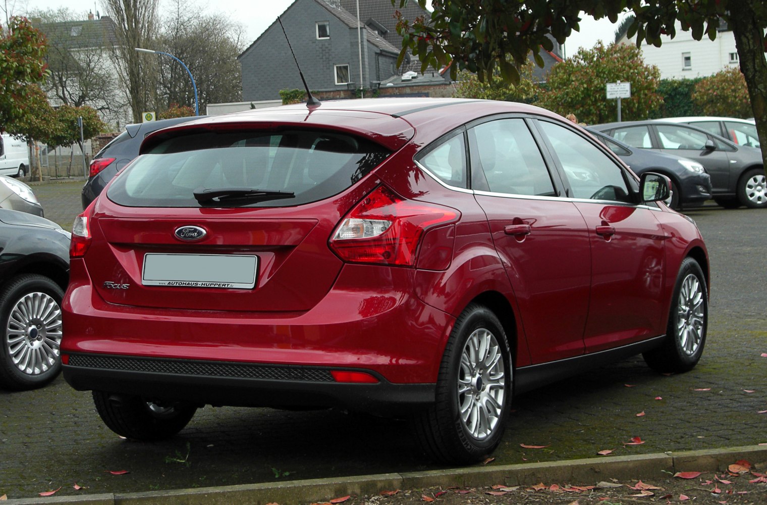 Red hatchback rear view with tail lights and alloy wheels